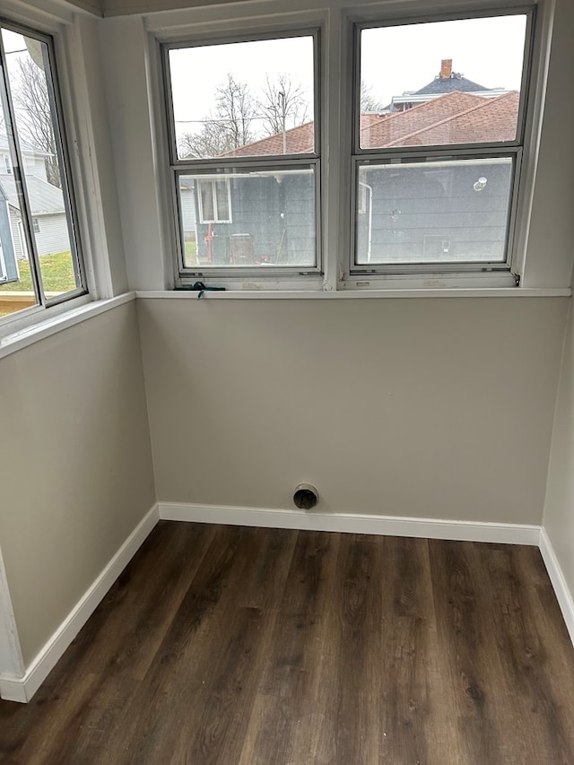 empty room featuring baseboards and dark wood-style floors