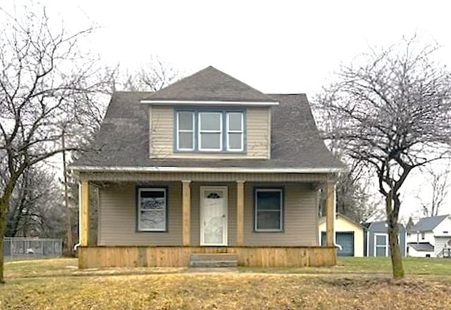 bungalow featuring a front yard, a porch, and a detached garage