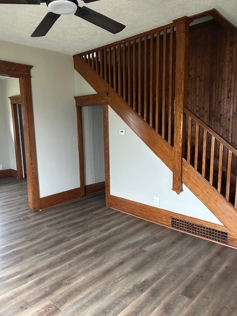 additional living space with baseboards, a textured ceiling, a ceiling fan, and wood finished floors