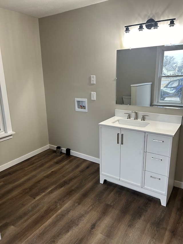 bathroom featuring vanity, baseboards, and wood finished floors