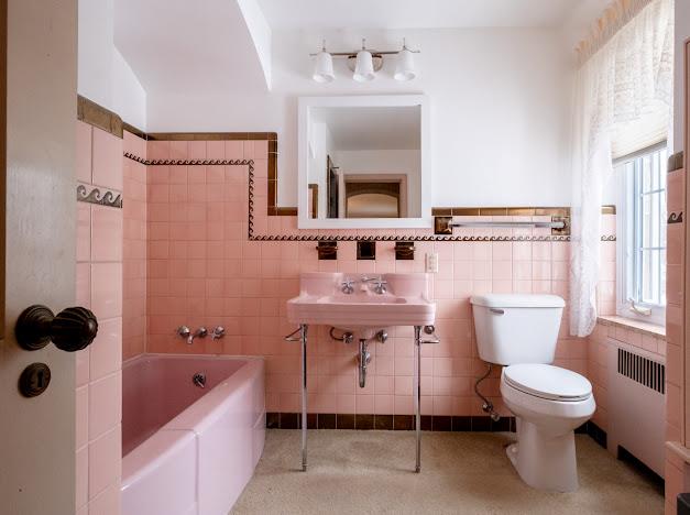 bathroom featuring a washtub, radiator heating unit, tile walls, and toilet