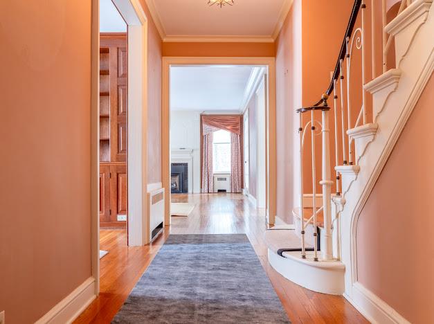 corridor featuring wood-type flooring and crown molding