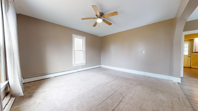 empty room featuring light carpet, ceiling fan, and baseboard heating