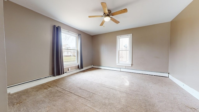 carpeted empty room with ceiling fan, plenty of natural light, and a baseboard radiator