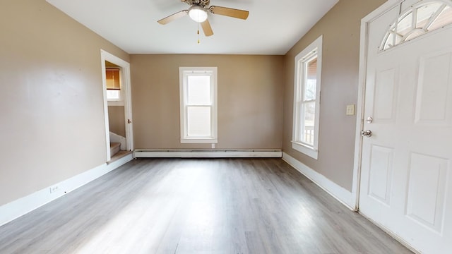 entryway with plenty of natural light, light hardwood / wood-style floors, ceiling fan, and baseboard heating