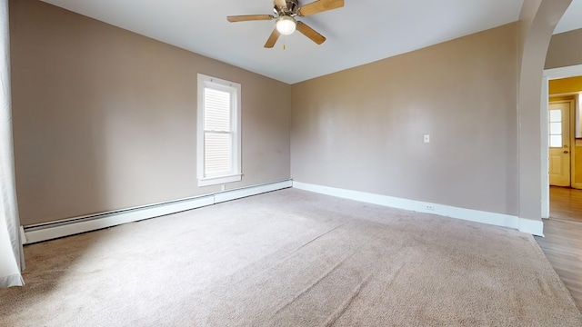 carpeted empty room featuring a baseboard heating unit and ceiling fan