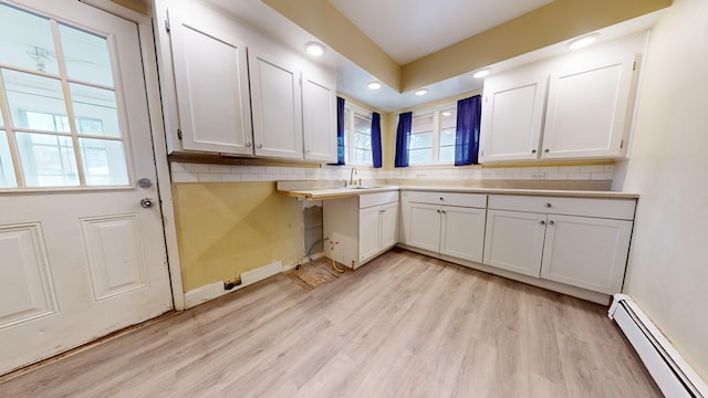 laundry area featuring sink, a baseboard radiator, and light wood-type flooring