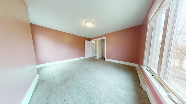 unfurnished room with a wealth of natural light, light carpet, and a baseboard radiator