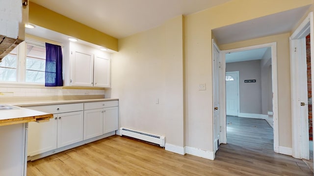 kitchen with white cabinetry, a baseboard heating unit, tasteful backsplash, and light hardwood / wood-style floors