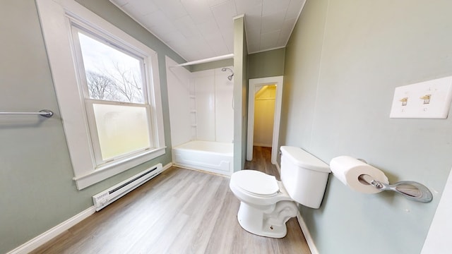 bathroom featuring hardwood / wood-style flooring, shower / tub combination, toilet, and a baseboard heating unit