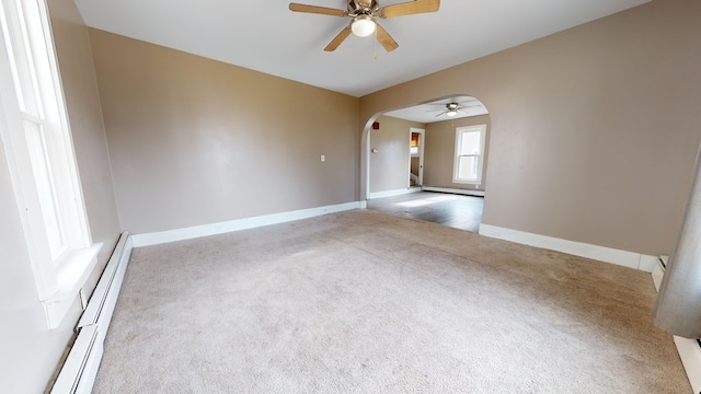 carpeted empty room with a baseboard radiator and ceiling fan