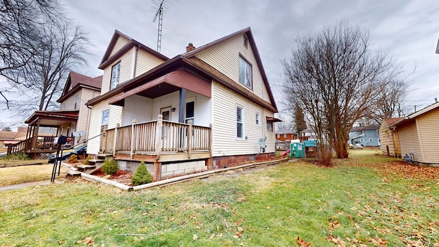 rear view of property with a yard and covered porch