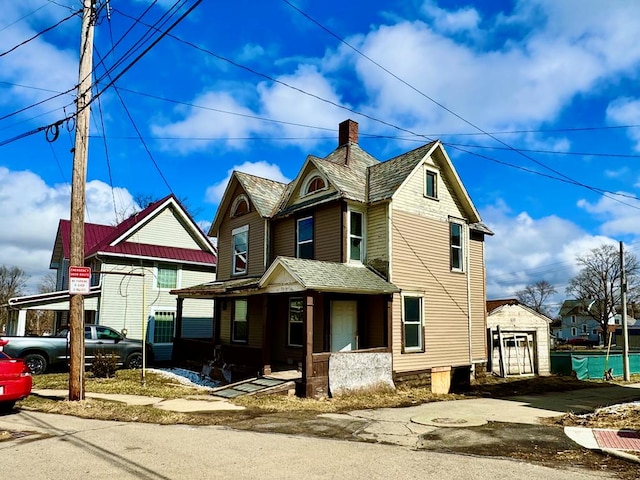 view of front facade featuring a porch and a chimney