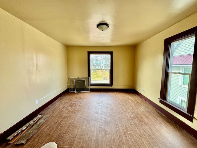 unfurnished room with baseboards and wood finished floors