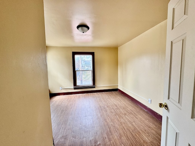 unfurnished room featuring baseboards and wood finished floors