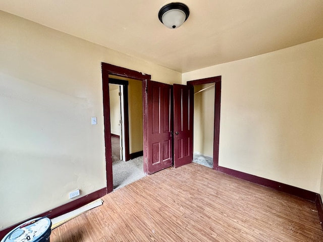 unfurnished room featuring light wood-type flooring and baseboards