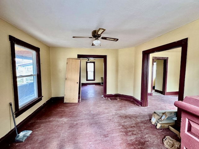 empty room with a wealth of natural light, baseboards, and a ceiling fan