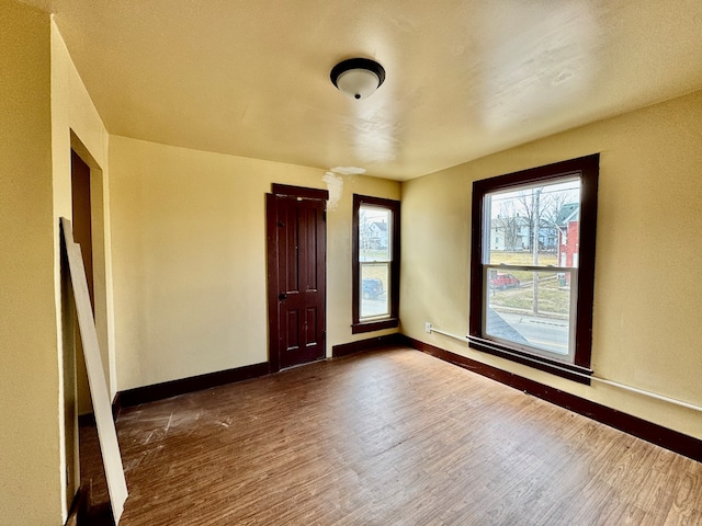 spare room featuring dark wood finished floors and baseboards