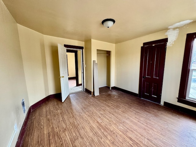 unfurnished room featuring visible vents, baseboards, and wood finished floors