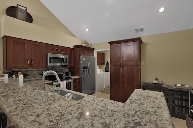 810 Whippoorwill Ln, Mansfield, OH 44906 - kitchen with stainless steel appliances, washing machine and dryer, light stone counters, decorative backsplash, and lofted ceiling