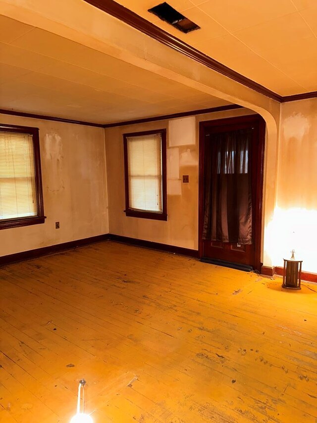 interior space with hardwood / wood-style flooring, baseboards, and ornamental molding