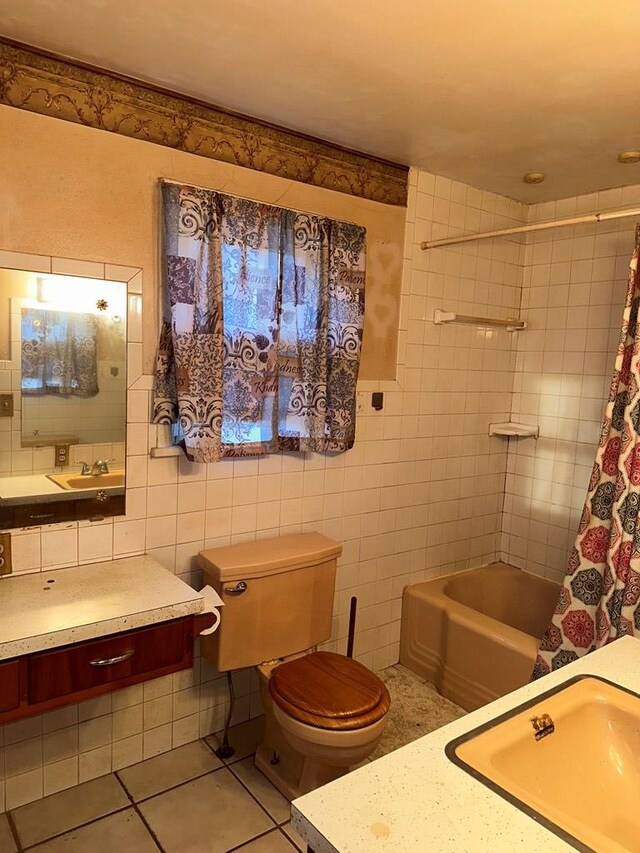 full bathroom featuring tile patterned flooring, tile walls, toilet, shower / tub combo with curtain, and vanity