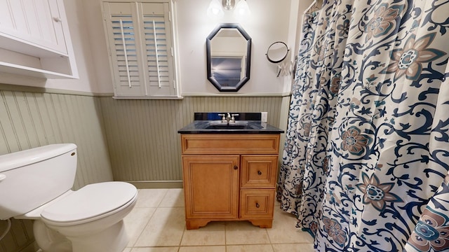 bathroom featuring wood walls, tile patterned flooring, vanity, and toilet