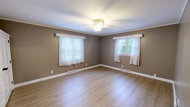 spare room with ceiling fan, light wood-type flooring, and crown molding