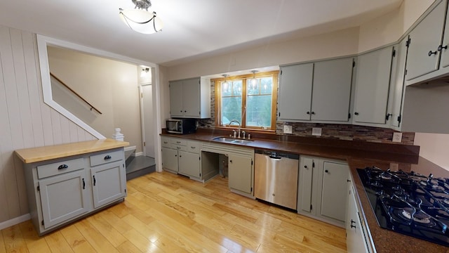 kitchen with decorative backsplash, light wood-type flooring, gray cabinetry, sink, and black appliances