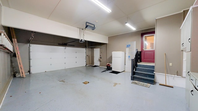 garage with white fridge and a garage door opener