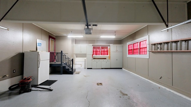 garage with white fridge and a garage door opener