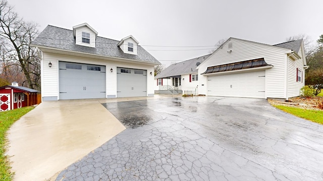 view of front of home with a garage and a shed