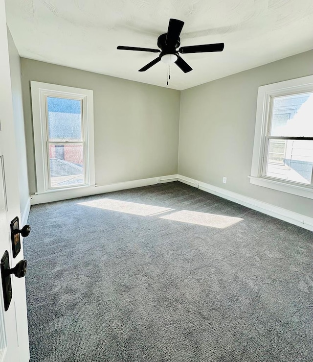 unfurnished room with ceiling fan and carpet