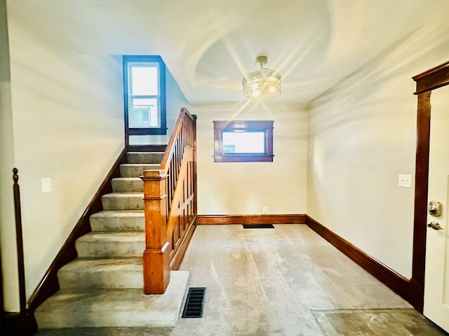 stairway featuring ceiling fan