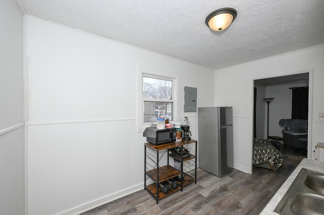 office featuring a textured ceiling, dark wood-style flooring, a sink, and electric panel