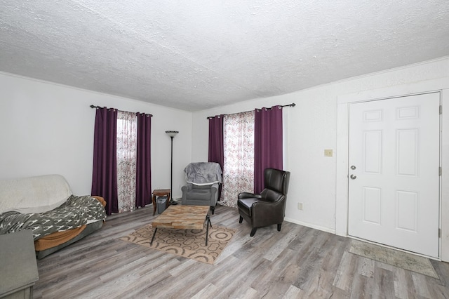 sitting room with plenty of natural light, a textured ceiling, and wood finished floors