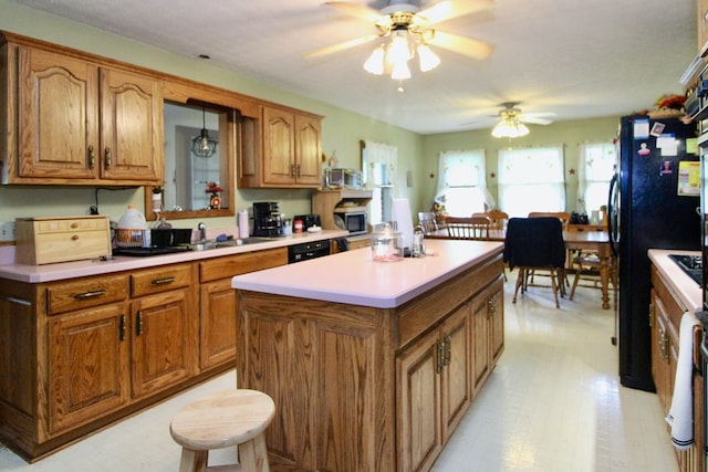 1320 Oakridge Rd, Bucyrus, OH 44820 - kitchen with black appliances, ceiling fan, brown cabinets, and a kitchen island