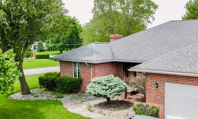 1320 Oakridge Rd, Bucyrus, OH 44820 - view of front of house with roof with shingles, a chimney, brick siding, a front yard, and an attached garage