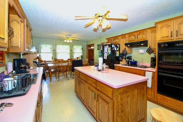 1320 Oakridge Rd, Bucyrus, OH 44820 - kitchen featuring black appliances, under cabinet range hood, a textured ceiling, a ceiling fan, and brown cabinetry
