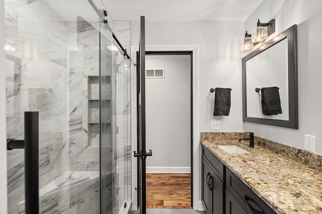 bathroom with vanity, hardwood / wood-style flooring, and a shower with door