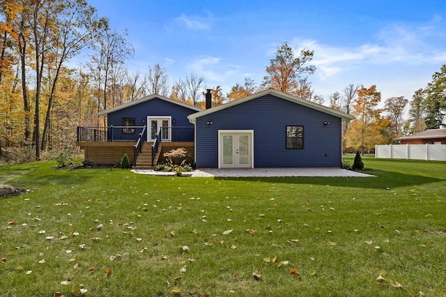 rear view of property with a lawn, a patio area, a deck, and french doors