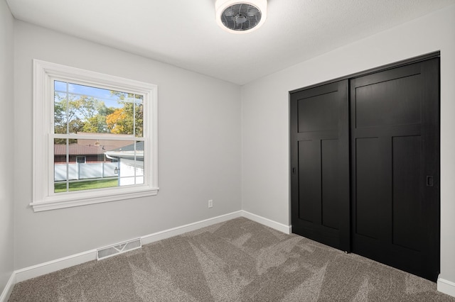 unfurnished bedroom with a closet and carpet floors