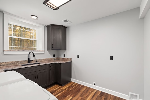 kitchen featuring dark hardwood / wood-style floors, light stone countertops, dark brown cabinetry, and sink