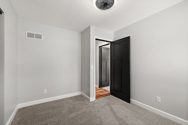 unfurnished bedroom with carpet flooring and a textured ceiling