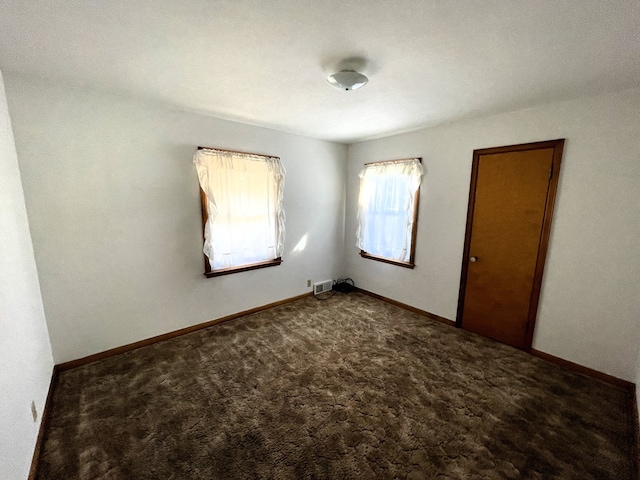 spare room featuring visible vents, baseboards, and carpet