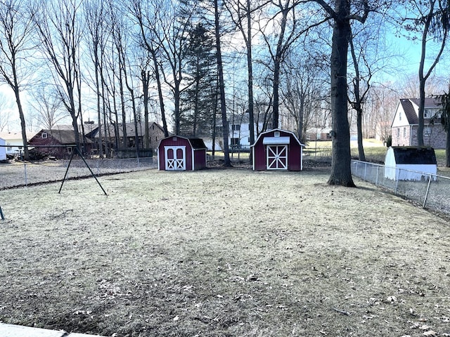 view of yard with a shed, an outdoor structure, and fence