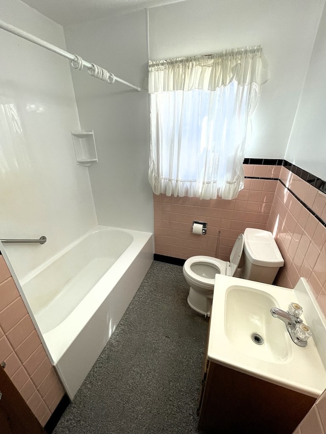 bathroom featuring vanity, a wainscoted wall, shower / tub combination, tile walls, and toilet