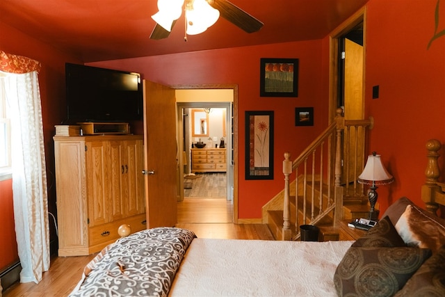 bedroom featuring light wood finished floors, a baseboard radiator, and a ceiling fan