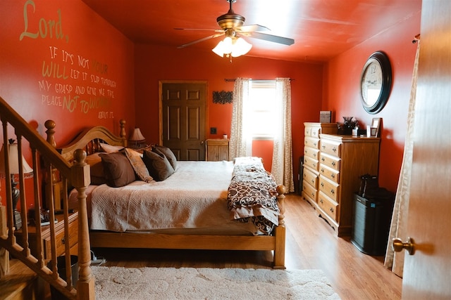 bedroom with vaulted ceiling, a ceiling fan, and light wood-style floors