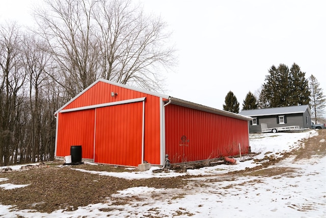 snow covered structure with an outbuilding